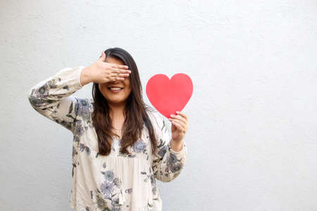 Latin adult woman shows her enthusiasm for the arrival of February and celebrate Valentine's Day of...