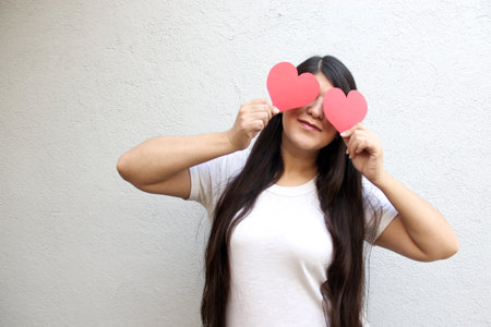 Latin adult woman shows her enthusiasm for the arrival of February and celebrate Valentine's Day of...