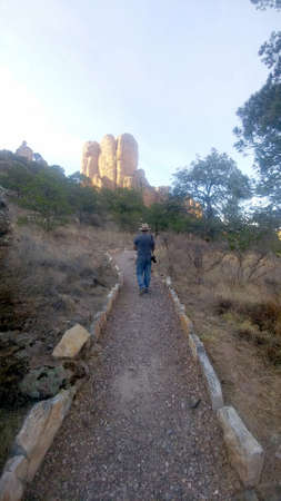 Latino adult man with hat and camera explores and discovers the great rock formations of Sierra de Organos in Zacatecas Mexicoの写真素材