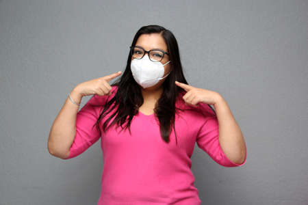 Latino adult woman with glasses wearing face masks for protection from Covid-19 due to the pandemicの写真素材