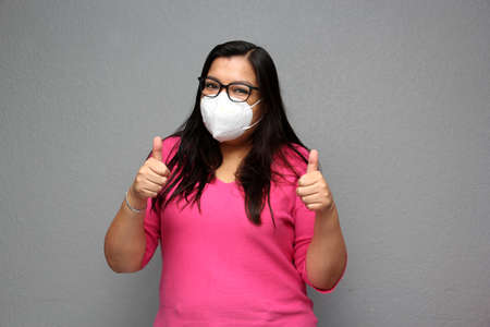 Latino adult woman with glasses wearing face masks for protection from Covid-19 due to the pandemicの写真素材