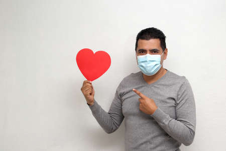 Latino adult man with face mask as protection in the new normality due to the Covid-19 pandemic...
