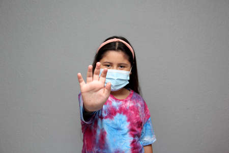 Happy Latin Little Girl Wearing Face Masks To Protect Herself From Coronavirus In The New Normal Due...