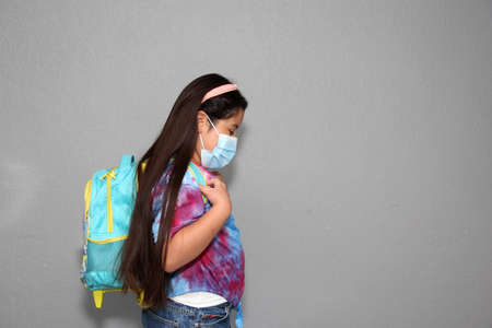 Girl prepare for back to school in the new normal due to the Covid-19 pandemic with backpack and face shield to protect from Coronavirusの写真素材