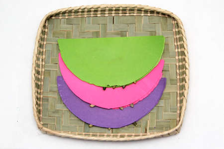 Typical Mexican sweet Pepitorias colored wafers glued with caramel or honey decorated with pipa seeds and chocolate chips on a basket traditional in Mexico as a dessertの写真素材