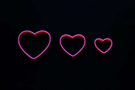 pink hearts on black background for valentine's day advertising banner