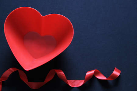box of red and pink hearts chocolates on black background with red ribbon, Valentine's Day, advertising bannerの写真素材