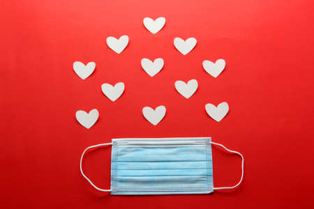 Tri-layer protective mask for clinical use with white hearts on a red backgroundの写真素材