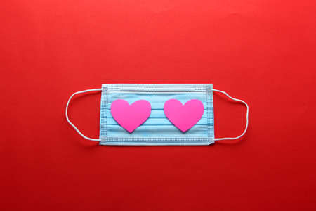 Tri-layer protective mask for clinical use with white hearts on a red backgroundの写真素材