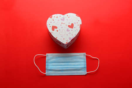 Valentine's Day in pendemic for covid-19, teddy bear, box of chocolates, flowers and hearts with protection mask clinical useの写真素材