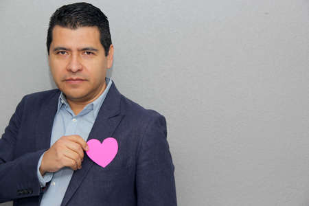 Formal latin man with blue jacket and red heart in his pocket. Valentine's Day