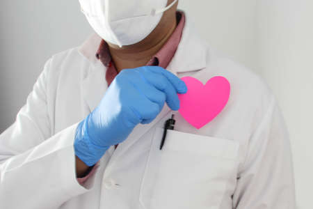 Valentine's Day. doctor with protection mask, latex gloves and gown, heart