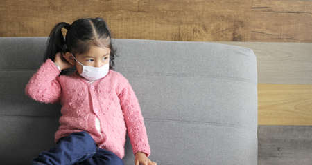 2 year old girl with protective face mask for new normal of covid-19 with colorful wall and background texturesの写真素材