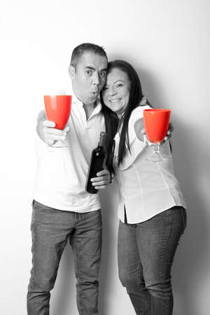 Latin adult couple in black and white show their love by toasting with red glasses for the arrival of February and celebrate Valentine's Love and Friendship Dayの写真素材