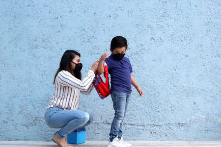 Latino family, mom and 6-year-old Latino boy with covid-19 protection mask, back to school with a new normalの写真素材