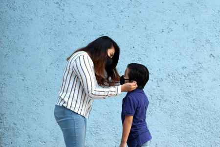 Latino family, mom and 6-year-old Latino boy with covid-19 protection mask, back to school with a new normalの写真素材