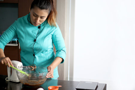Latin woman chef with black protection mask, preparing cake flour with kitchen utensils, new normal...