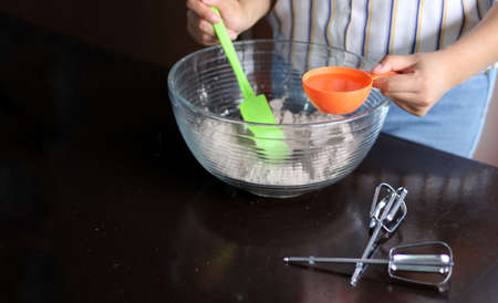 latin woman chef preparing whipping flour for cake with kitchen utensils