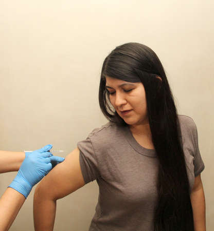 30-year-old Latin woman happy and scared with the Covid-19 vaccine shot