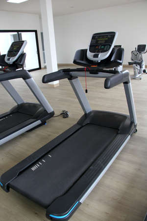 Fixed bike and electric treadmills for training and fitness. Exercise equipment in a gym without...