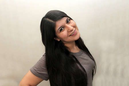 Latin woman with very long straight black hair happy showing her hair