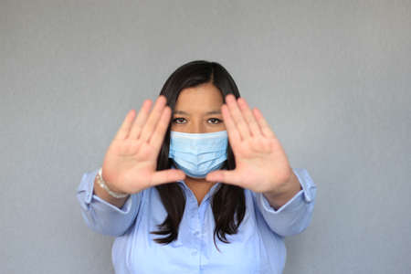 Latin woman with blue blouse and protection mask clinical use for covid pandemicの写真素材