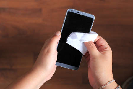 hygiene at home, Clean and disinfect cell phone with an antibacterial wipe, virus preventionの写真素材