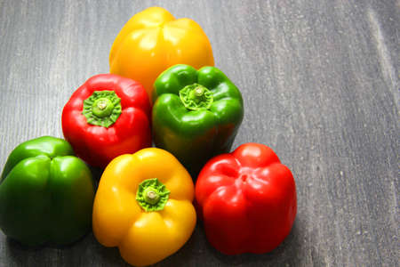 colorful vegetables and peas, yellow, green and red bell peppers on vintage gray wooden backgroundの写真素材