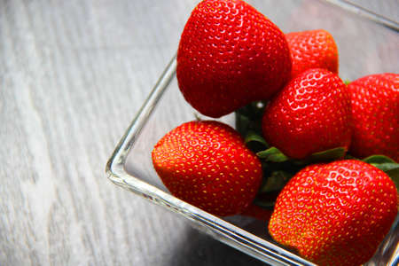 fruit red strawberries in glass bowl. vintage gray wood backgroundの写真素材
