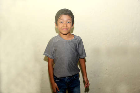 Happy 7 year old latin boy smiling chimuelo and posing with camera