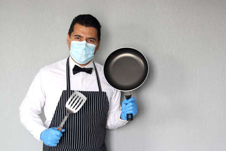 Latino chef serving coffee and food, working with latex gloves and face masks, new normal for the covid-19 virusの写真素材
