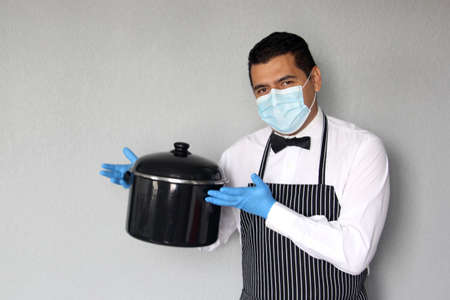 Latino chef serving coffee and food, working with latex gloves and face masks, new normal for the...