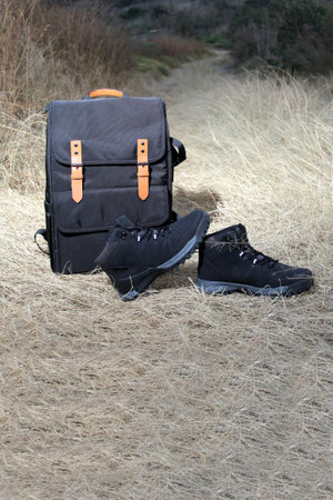 Backpack, and boots for hiking in the mountains at sunrise, equipment for extreme outdoor sport