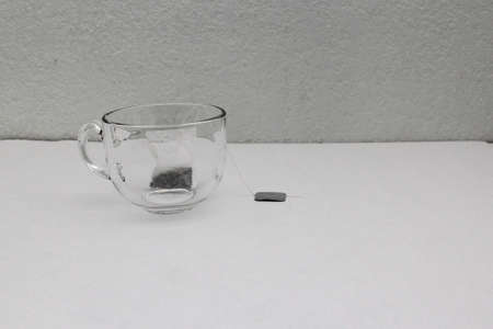 Tea making tools: glass cup, infuser, sachets, dried dehydrated herb, spoon, to relax and cure...