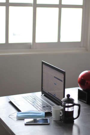 Coffee, mask and computer ready to work at home