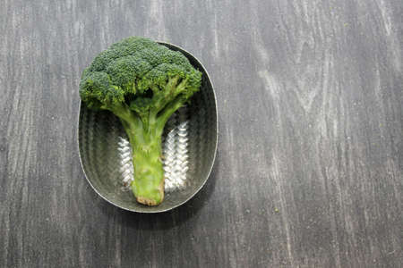 Fresh, raw and delicious freshly harvested broccoli ready to be chopped and cooked in a basketの写真素材