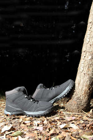 Black boots in the dark forest between trees ready for hiking in the mountains to explore at night