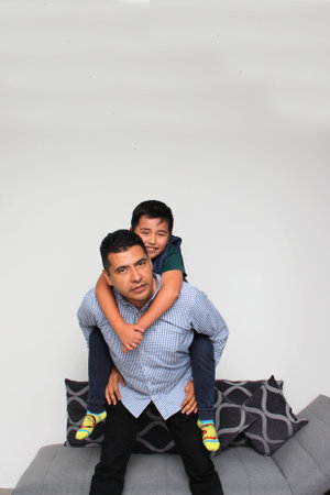 Latino dad plays with his Hispanic son with Autism Spectrum Disorder (ASD) Asperger Syndrome a...