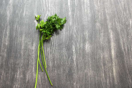 Green vegetables like parsley, celery, nopales, cucumbers, chard and spinach on a wooden table and...