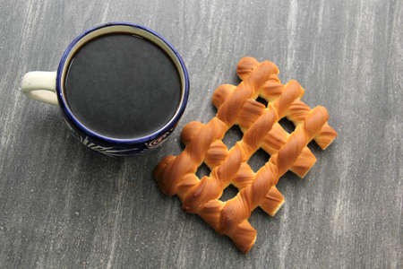 Hot coffee in a blue artisan cup accompanied by delicious, fresh and fluffy Mexican sweet bread: biscuit, croissant, grill, pancha eye and wormの写真素材