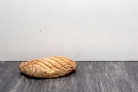 Fresh, fluffy, sugary and freshly made sweet bread stuffed with Mexican town cheese called worm on wooden table on colored napkin accompanied by hot coffeeの写真素材