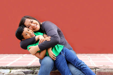 Single mom and dark-haired Latino son play and have fun together spending quality family time on Mother's Dayの写真素材