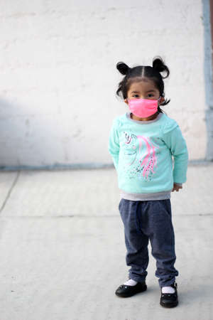 3-year-old Latina girl with covid-19 protection mask and backpack for back to school, new normal