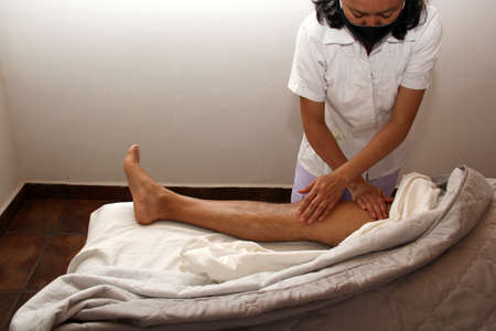 close up masseur in spa working, therapeutic massage and rehabilitation in legsの写真素材