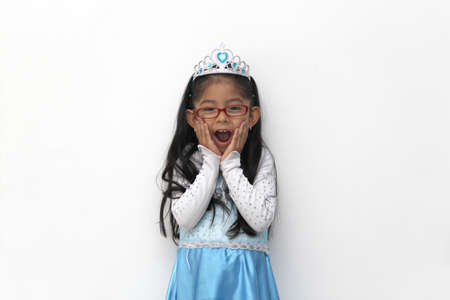 Poor 4-year-old Latin brunette girl is dressed as a happy princess with her costume to go to a children's party and feel strong and empoweredの写真素材
