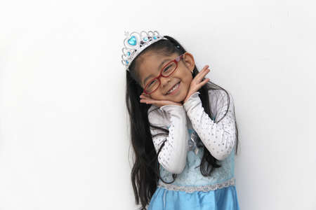 Poor 4-year-old Latin brunette girl is dressed as a happy princess with her costume to go to a children's party and feel strong and empoweredの写真素材