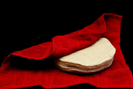 Freshly made and hot corn tortillas ready to eat and make Mexican tacos in a napkin to keep freshの写真素材