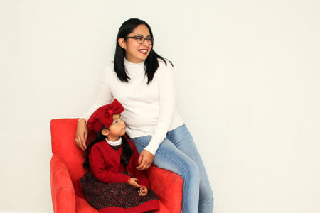 Latin mom and daughter show their family love very happy, elegant and casual, ready to celebrate the holidays like Christmas, New Years, Thnaksgiving, Love Day, Mother's Dayの写真素材