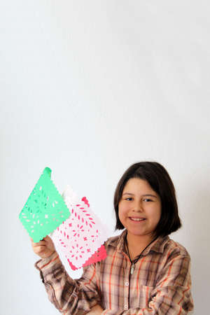 10-year-old Latina Hispanic girl plays with green white and red flags to celebrate the Mexican national holidays of May 5 and September 15の写真素材