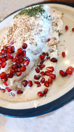 Chile en nogada typical dish from Puebla, Mexico. Poblano pepper, stuffed with minced meat and fruit, with acitrÃ³n covered with Castile nut cream (nogada), parsley leaves and pomegranateの写真素材